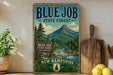 A vintage-style sign for the Blue Job State Forest in New Hampshire, featuring a mountain landscape and pine trees.