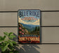 A vintage-style metal sign for Blue Ridge National Heritage Area, featuring a scenic mountain landscape with pine trees and wildflowers.