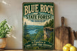 A vintage-style metal sign for Blue Rock State Forest in Ohio, featuring a scenic landscape with a cliff overlooking a lake.