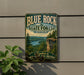 A vintage-style metal sign for Blue Rock State Forest in Ohio, featuring a scenic landscape with a river, cliffs, and trees.