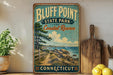 A vintage-style sign for Bluff Point State Park and Coastal Reserve in Connecticut, featuring a scenic coastal landscape with a path leading to the beach.