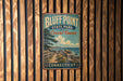 A vintage-style metal sign for Bluff Point State Park and Coastal Reserve in Connecticut, featuring a scenic coastal landscape with a path leading to a beach.