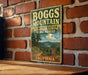 A vintage-style sign for Boggs Mountain, a demonstration state forest in California, is displayed on a brick wall.