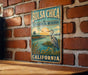 A vintage-style metal sign for the Bolsa Chica Ecological Reserve in California, featuring an illustration of a bird and a serene landscape.