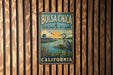 A vintage metal sign with the text "BOLSA CHICA ECOLOGICAL RESERVE CALIFORNIA" is displayed on a wooden wall.