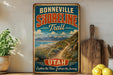 A vintage-style sign for the Bonneville Shoreline Trail in Utah, featuring a scenic mountain landscape and a path leading through the mountains.