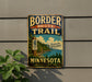 A vintage metal sign on a wall, advertising the Border Route Trail in Minnesota.