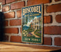 A vintage-style metal sign for Boscobel House and Gardens in New York, featuring a brick wall and a garden scene.