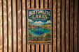 A vintage-style metal sign for Bottomless Lakes State Park in New Mexico, featuring a scenic landscape with a lake and mountains.