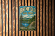 A vintage metal sign for the Brimfield State Forest in Massachusetts, featuring a scenic landscape with a lake and mountains.