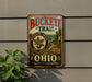 A vintage-style metal sign for Buckeye Trail in Ohio, featuring a scenic illustration of a forest and a path leading through the landscape.