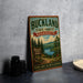 A vintage-style metal sign for Buckland State Forest in Massachusetts, featuring a scenic landscape with pine trees, a lake, and mountains.
