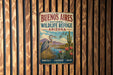 A vintage metal sign for Buenos Aires National Wildlife Refuge in Arizona, featuring a bird, cactus, and flowers, mounted on a wooden wall.