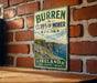 A vintage-style sign for Burren Cliffs of Moher Park in Ireland, featuring a scenic image of the cliffs and the surrounding landscape.