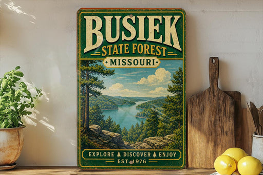 A vintage-style sign for Busiek State Forest in Missouri, featuring a scenic landscape with a lake and mountains.
