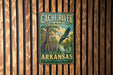 A vintage-style metal sign for the Cacher River National Wildlife Refuge in Arkansas, featuring a bird in flight and a lush, swampy landscape.