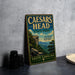 a vintage metal sign for Caesar's Head State Park, with a scenic mountain landscape in the background.