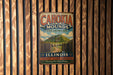 A vintage metal sign for Cahokia Mounds State Historic Site in Illinois, featuring a mountain landscape and the text "Cahokia Mounds" and "State Historic Site".