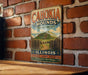 A vintage metal sign for the Cahokia Mounds State Historic Site in Illinois, featuring a mountain landscape and text promoting exploration and learning about the site.