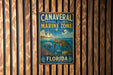 A vintage metal sign for the Canavorial National Seashore Marine Zone in Florida, featuring a turtle and other marine life against a backdrop of a lighthouse and ocean.