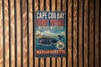 A vintage metal sign for Cape Cod Bay, Massachusetts, featuring a right whale and the text "Right Whale Critical Habitat" in a blue and red color scheme.