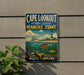 A vintage-style metal sign for Cape Lookout National Seashore Marine Zone, featuring a lighthouse, a boat, and marine life, is displayed on a wall.