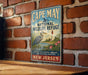 A vintage-style metal sign for Cape May National Wildlife Refuge, featuring a blue background with a bird illustration and text promoting the refuge's mission to protect coastal wildlife and natural habitats in New Jersey.