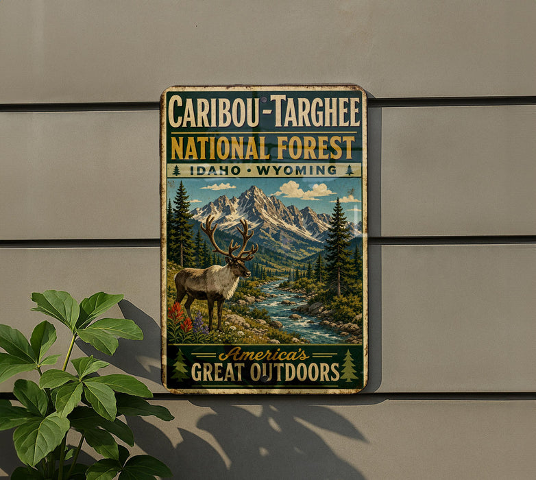 A vintage-style metal sign advertising the Caribbean-Targhee National Forest in Idaho, Wyoming, featuring a reindeer and a scenic mountain landscape.