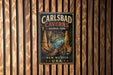 A vintage-style metal sign for Carlsbad Caves National Park in New Mexico, USA, featuring an illustration of the cave system.