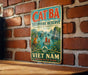 A vintage metal sign with the text "CAT BA BIOSPHERE RESERVE NATURE IN HARMONY VIET NAM" and a picture of a jungle scene with a boat.