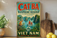 A vintage-style sign for the Cat Ba Bioscape Reserve in Vietnam, featuring a monkey and a boat on a tropical island.