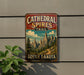 A vintage metal sign for the Cathedral Spires Trail in South Dakota, featuring a scenic mountain landscape.