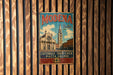 A vintage metal sign with the text "MODENA Italia" and an illustration of a church and a clock tower, hanging on a wooden wall.