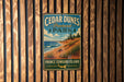 A vintage metal sign for Cedar Dunes Provincial Park, featuring a scenic coastal landscape with a beach, grassy dunes, and a body of water.