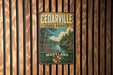 A vintage metal sign for Cedarville State Forest in Maryland, featuring a scenic landscape with pine trees, a river, and a state seal.