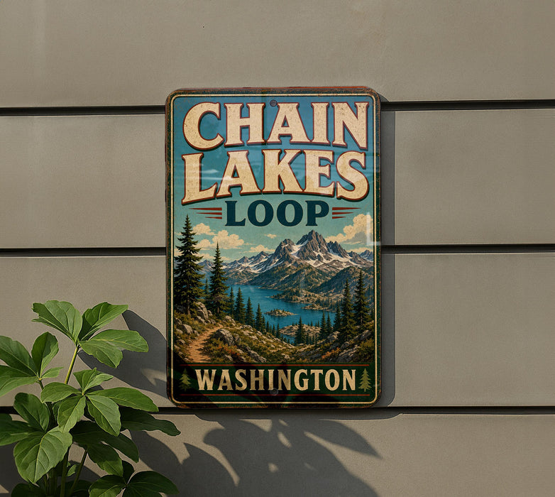 A vintage-style metal sign for Chain Lakes Loop in Washington, featuring a scenic mountain landscape with pine trees and a lake.