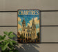 A vintage-style metal sign displaying the name "Catres Cathedral" and the word "FRANCE" is mounted on a wall.