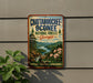 A vintage metal sign advertising the Chattahoochee Oconee National Forests in Georgia, featuring a scenic landscape with mountains, forests, and a river.