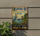 A vintage-style metal sign for Chesapeake Bay National Estuarine Research Reserve, featuring an illustration of a heron and a lighthouse.