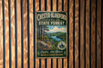 A vintage metal sign for Chester-Blandford State Forest, featuring a scenic landscape with pine trees, a river, and mountains.