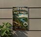 A vintage metal sign for Chester-Blandford State Forest, featuring a scenic landscape with pine trees, a river, and mountains in the background.