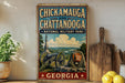 A vintage-style metal sign displaying the text "CHICKAMAUGA AND CHATANOOGA NATIONAL MILITARY PARK GEORGIA" with an illustration of a cannon and a monument.