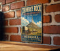 A vintage-style metal sign for Chimney Rock National Historic Site in Nebraska, featuring a wagon train and a mountain in the background.
