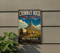 A vintage-style metal sign for Chimney Rock National Historic Site in Nebraska, featuring a wagon train and a mountain in the background.