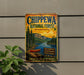 A vintage metal sign for Chippewa National Forest in Minnesota, featuring a scenic illustration of a lake, mountains, and pine forests.