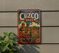 A vintage-style metal sign with the text "CITY OF CUZCO PERU" and an illustration of a historic building, likely representing the ancient capital of Peru.
