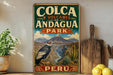 A vintage-style metal sign for Colca y Volcanes de Andagua Park in Peru, featuring a mountain landscape with a bird in flight.