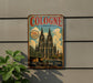 A vintage metal sign advertising the Cologne Cathedral in Germany, featuring an illustration of the cathedral and a bridge.