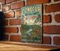A vintage metal sign for Conecuh National Forest in Alabama, featuring a scenic illustration of a forest landscape with a deer.