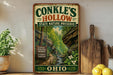 A vintage-style metal sign for Conkles Hollow State Nature Preserve in Ohio, featuring a scenic image of a forest and a winding path.